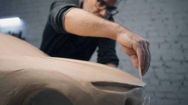 Araba tasarımcısı, araba tasarımını oymak için tel uçlu araç kullanan bir prototip arabanın heykeli üzerinde yakından çalışıyor. Tasarım değişiklikleri yapar ve mükemmelleştirir. Arabanın prototip modeli..