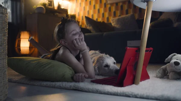 Menina Deitada Tapete Suave Com Cão Assistindo Filmes Engraçados Computador — Fotografia de Stock