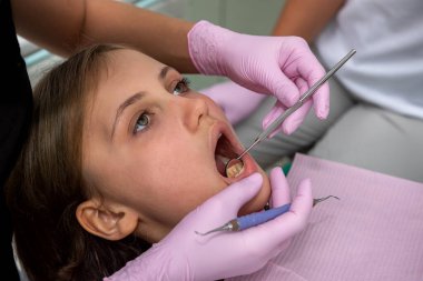 Dişçi klinikteki hastanın ağız boşluğunu inceliyor. tıbbi konsept