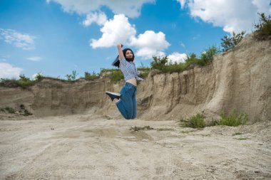 Kadın kum dağının arka planında poz veriyor, yaz yaşam tarzı, doğanın güzelliği.