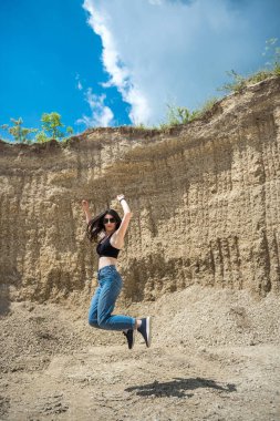 Genç bir kadın kum ocağında hafif egzersizler yapıyor. yoga. Doğada rahatlama. güneşli bir gün