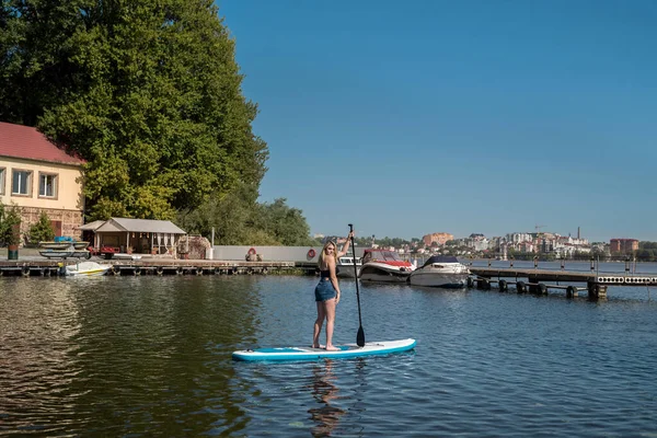 young pretty woman on SUP board enjoy summer lifestyle in city lake