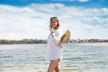 Sıcak suda duran güzel sarışın seksi bayan, gölün yanında güneşli havanın tadını çıkar. 