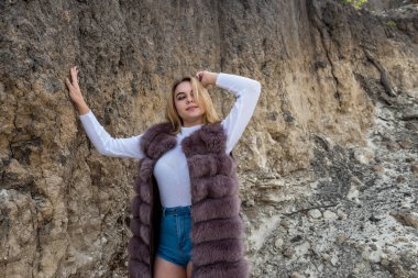Kum dağlarında görev yapan genç bir moda kadını. Sıcak bir sonbahar güneşli gününün tadını çıkarır.