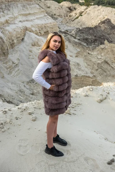 砂の岩の上にポーズを毛皮のコートのファッション若い女性 自然の中での自由 — ストック写真