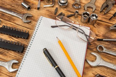 Boş not defteri inşaat aletlerinin etrafını sarmış. Tamir ekipmanları. İşyeri