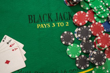 Yeşil kumarhane masasında oyun kartları olan poker fişleri. Kumar