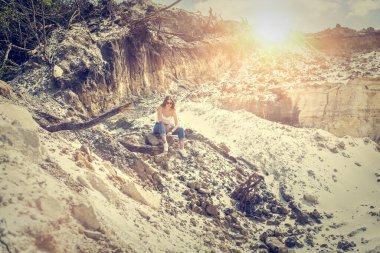  Genç bayan model dışarıda, kum ocağında poz veriyor ve dinleniyor. Çekici kadın dinleniyor.