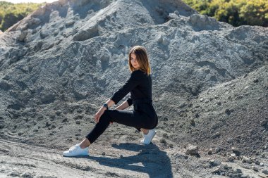 Tulum giymiş güzel bir kadın yaz mevsiminde kum ocağında kameraya poz veriyor.