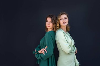 Güzel iki kız yazın doğada muhteşem yeşil elbiseler içinde poz veriyor. kadın portresi