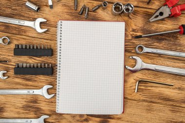 Boş not defteri inşaat aletlerinin etrafını sarmış. Tamir ekipmanları. İşyeri