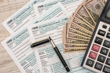 Nisan 'da doldurmak için 1040 dolar ve hesap makinesi. Vergi kavramı.