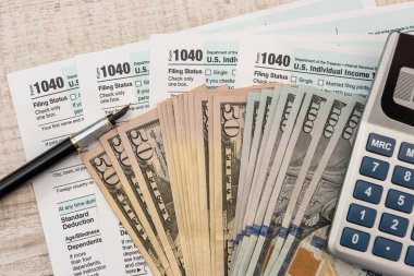 ABD bireysel 1040 formu, dolar hesap makinesi ve kalem kağıtlarıyla. muhasebe kavramı