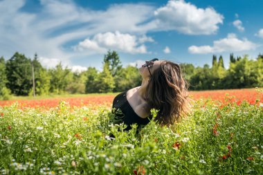 Çiçek tarlasında güzel bir genç kadın papatyalar, doğanın tadını çıkar. yaz zamanı