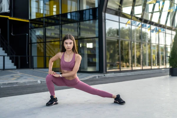 Młoda Kobieta Fitness Robi Rozciągające Ćwiczenia Jogi Pobliżu Nowoczesnego Budynku — Zdjęcie stockowe