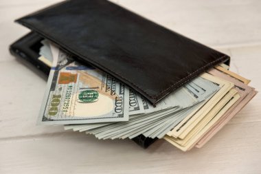 Koyu deri bir cüzdanda dolar banknotları, mali geçmiş.