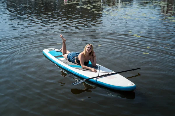 Hübsches Mädchen Auf Einem Paddelbrett Auf Dunkelblauem Teichwasser Liegend Reise — Stockfoto
