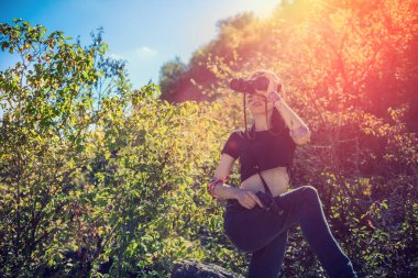 Seksi kadın asker doğada dürbün kullanıyor. Savaşçı