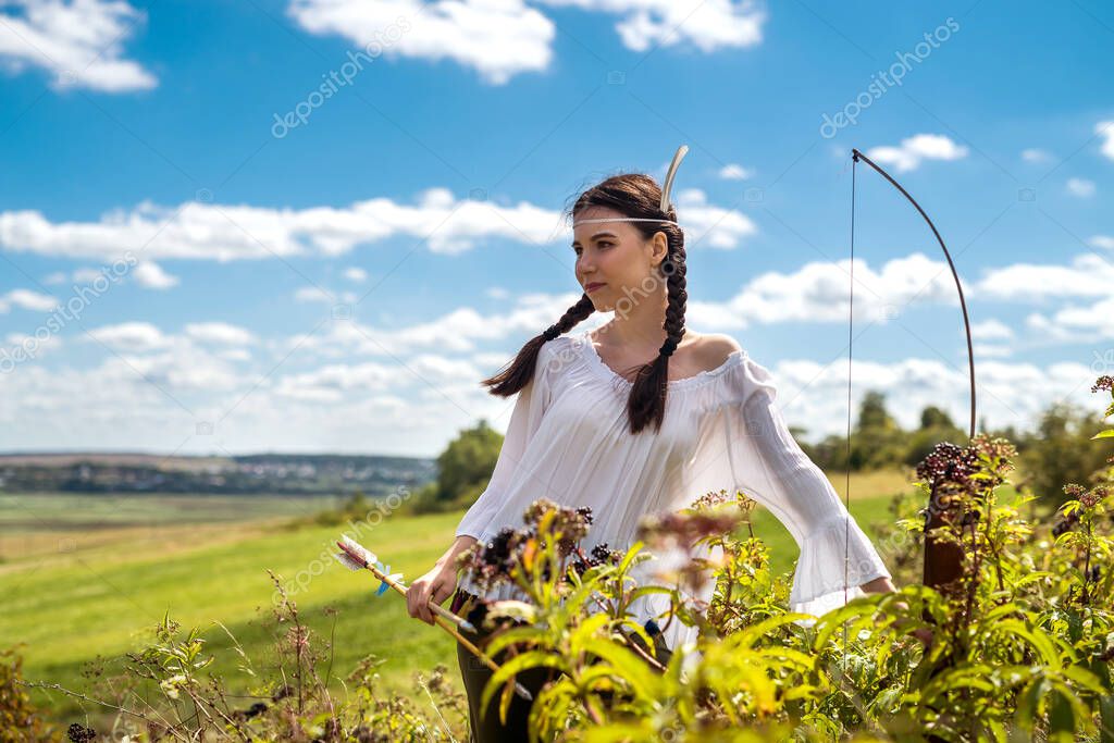 portrait of pretty Indian woman poses in a nature surrounding. native american female hunter outdoor
