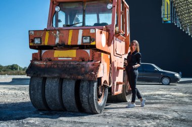 Paver makinesinin yanında poz veren güzel bir kız. Yaşam biçimi