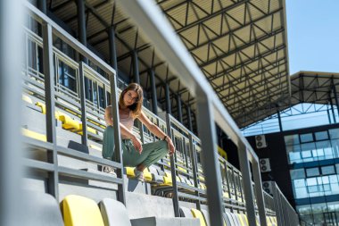 Stadyum sandalyesinde dinlenen ya da sabah egzersizi yapan güzel spor kadınlarının portresi. sağlıklı yaşam tarzı