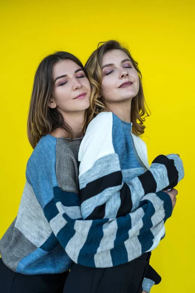 Young Girlfriends Posing Together Modern Knitted Sweaters Isolated Yellow Wall — Stock Photo, Image