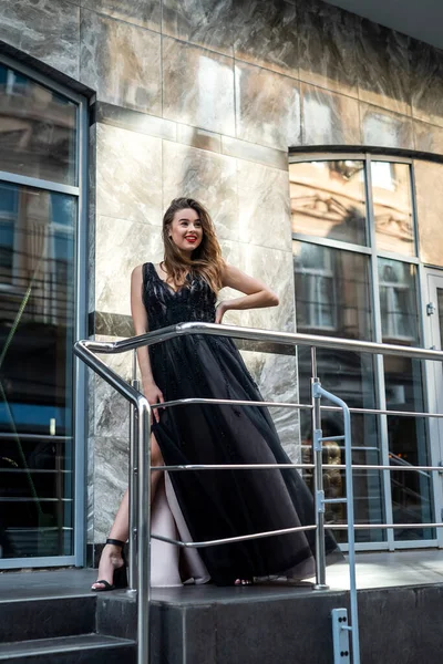 아름다운 저녁검은 드레스를 매력적 모델의 초여름 도시의 거리에서 포즈를 취하는 — 스톡 사진