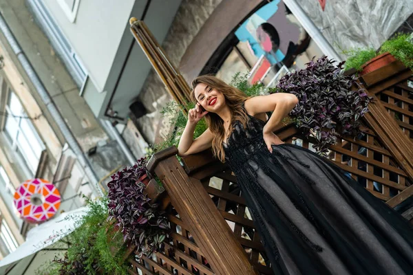 Молодая Брюнетка Элегантном Черном Вечернем Платье Posign Рядом Стеклянным Зданием — стоковое фото
