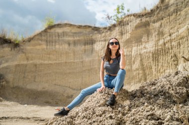 Güzel bir kız mavi gökyüzüyle kumların üzerinde yürüyor. Mükemmel yaz güneşli tatil günü