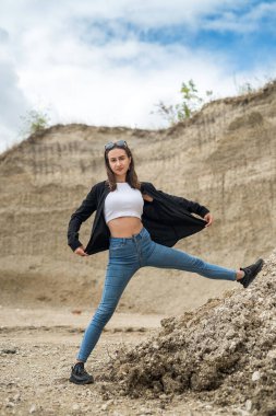 Genç bir kadın kum ocağında hafif egzersizler yapıyor. yoga. Doğada rahatlama. güneşli bir gün