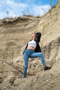 Çekici genç kız kumlu bir kanyon taşocağında seyahat ediyor ve yaz tatilinin tadını çıkarıyor.