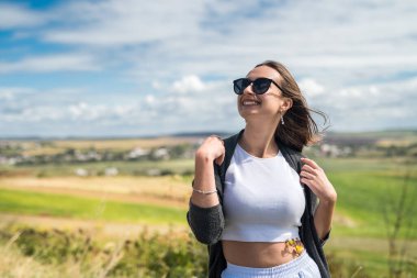 Güzel kız, uzun çimenli bir çayırda güneşli bir yaz gününün tadını çıkarıyor. Yaşam biçimi