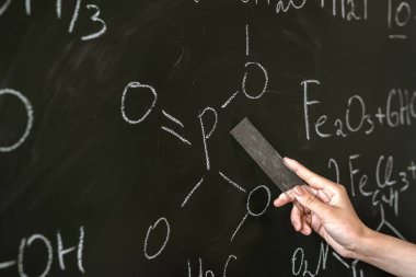 Sınıf tahtasında kimya öğretmeni yazma ve kimyasal formülü açıklama, çalışma