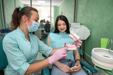 Diş hekimi olan genç bir kadın diş hijyeninden bahsediyor.