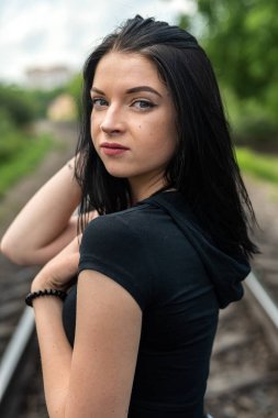 Tren yolu kenarında poz veren güzel bayan, yaz tatili zamanı.