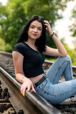Tren yolu kenarında poz veren güzel bayan, yaz tatili zamanı.