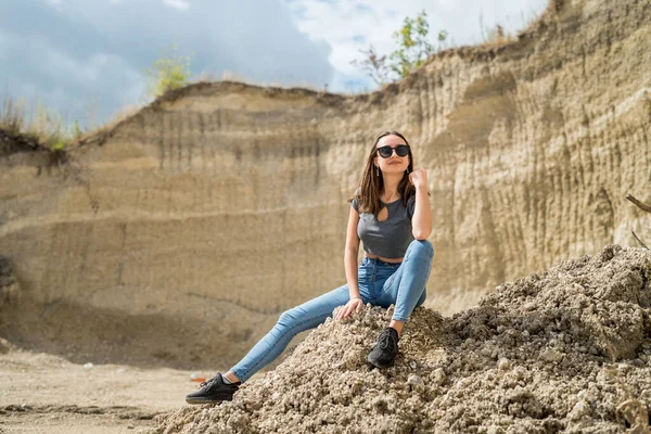 Güzel bir kız mavi gökyüzüyle kumların üzerinde yürüyor. Mükemmel yaz güneşli tatil günü