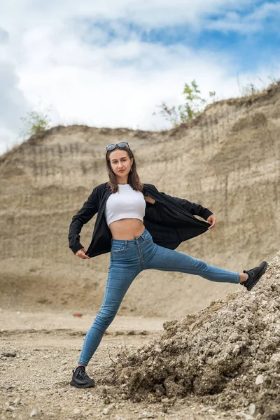 Genç bir kadın kum ocağında hafif egzersizler yapıyor. yoga. Doğada rahatlama. güneşli bir gün