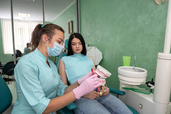 Diş hekimi olan genç bir kadın diş hijyeninden bahsediyor.