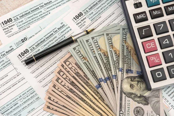 Nisan 'da doldurmak için 1040 dolar ve hesap makinesi. Vergi kavramı.