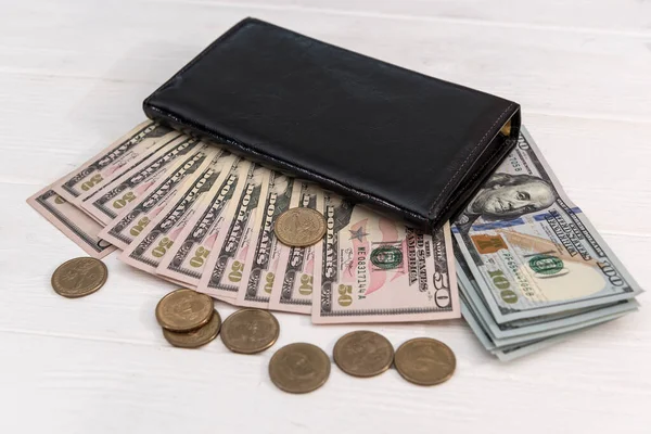 Dolar banknotları ve sent paraları olan siyah cüzdan, tasarruf kavramı