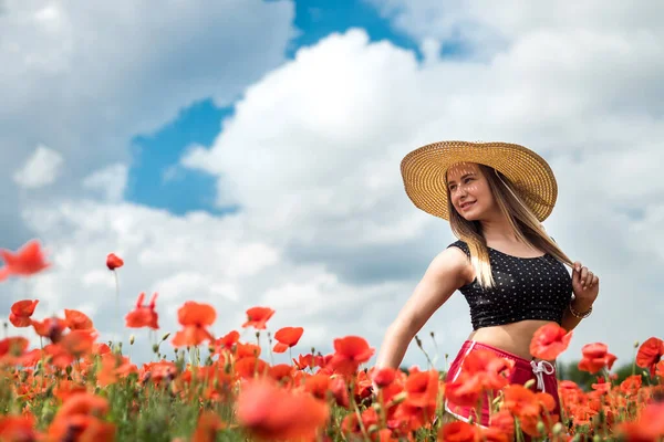 美丽的乌克兰人 身披黑色上衣 戴着帽子 在红罂粟地里享受着阳光灿烂的日子 — 图库照片