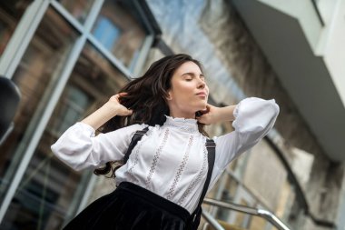 Güzel bir kadın yaz tatilinin tadını çıkarıyor. Şehir merkezindeki kafe yakınlarında, yaşam tarzında.