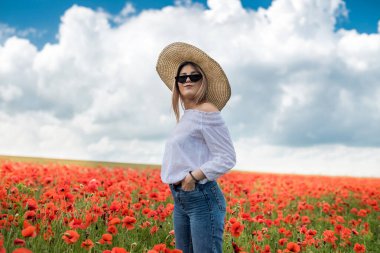 Beyaz model, güneşli bir günde haşhaş tarlasında hayatın tadını çıkarıyor. sağlık yaşam tarzı