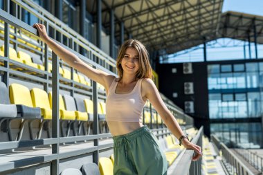 Stadyum sandalyesinde dinlenen ya da sabah egzersizi yapan güzel spor kadınlarının portresi. sağlıklı yaşam tarzı