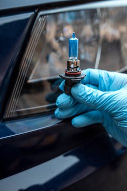 Tamirci araba ampulünü far ve otomobil servisiyle değiştiriyor.