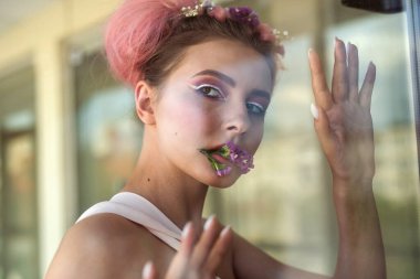 Moda makyajlı, kameraya poz veren çekici bir kadın.