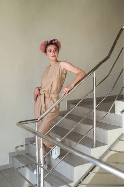 Binanın içindeki merdivenlerde poz veren genç bayan.