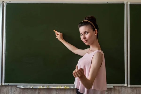 Hübsche Lehrerin Erklärt Neue Unterrichtsstunde Nahe Der Leeren Schultafel Kopiert — Stockfoto