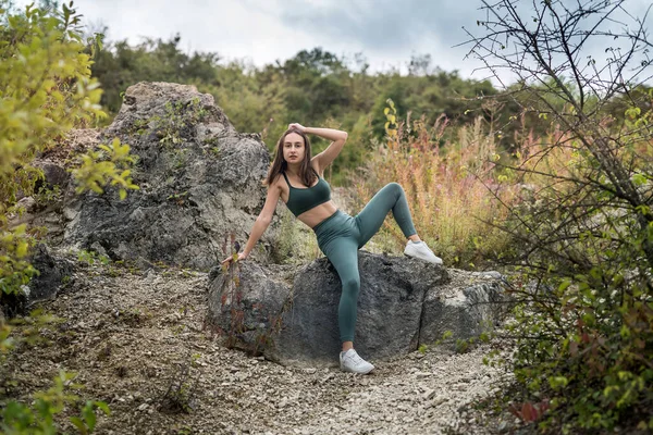 Güzel bir kız kayalıklarda büyük bir taşın üzerinde dinleniyor. Yaşam biçimi